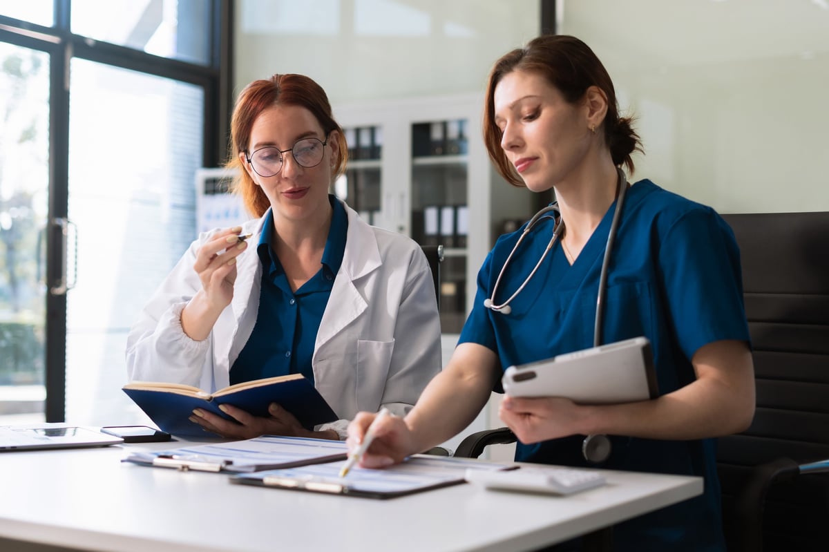 Healthcare team reviewing patient charts and progress notes together