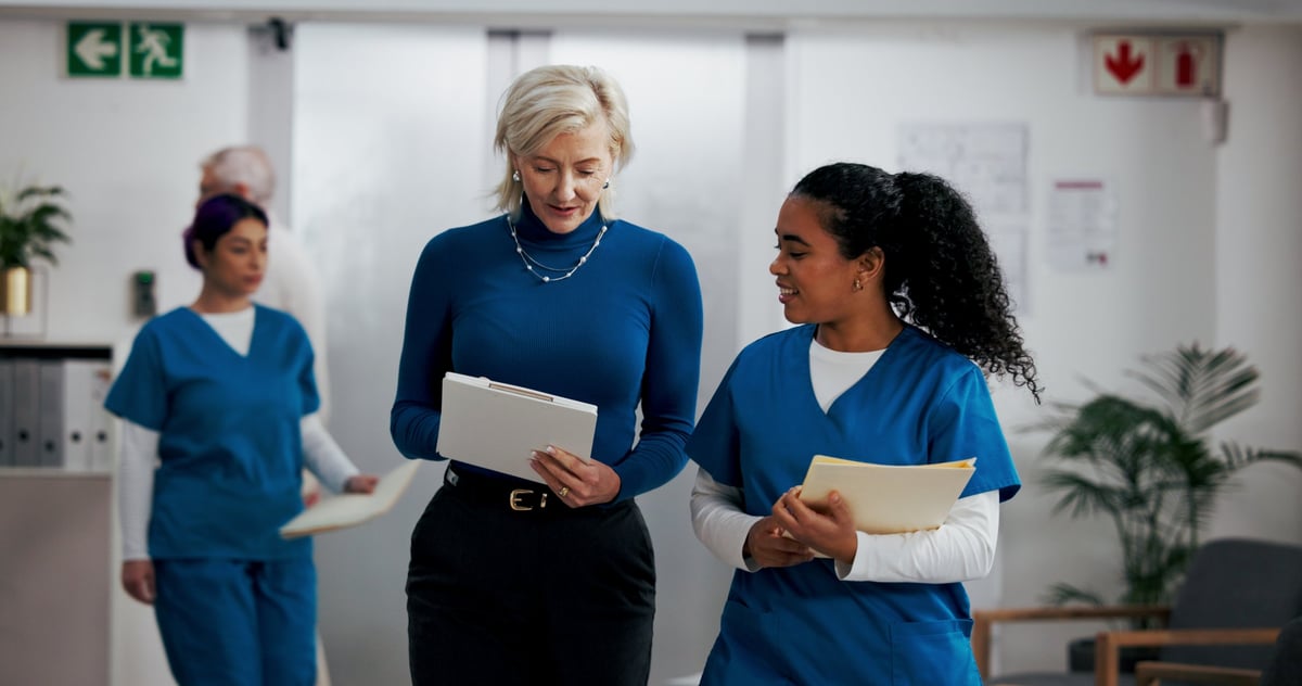 Hospital managers reviewing a surgery schedule and patient report on a tablet